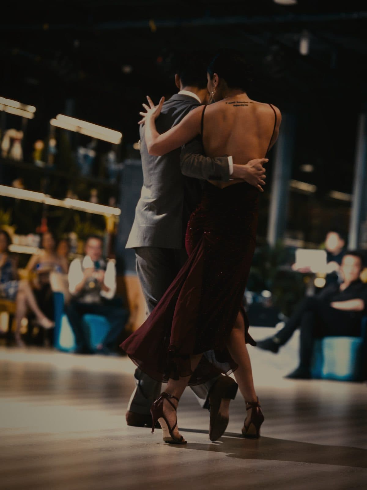 A couple dancing closely under warm light